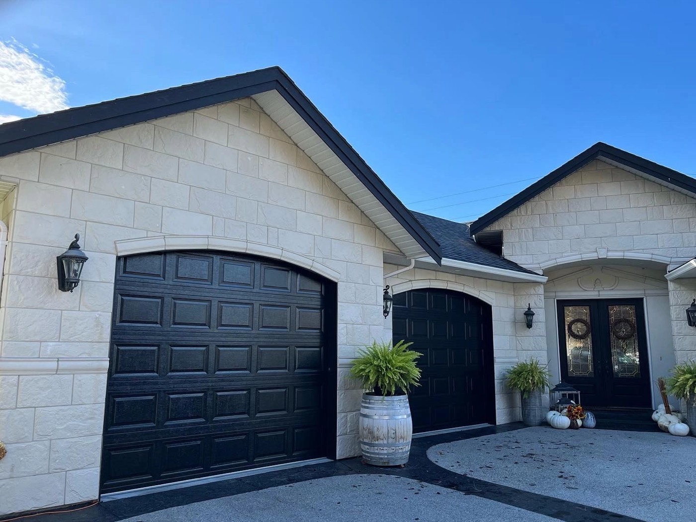 Cream house exterior with freshly painted black garage door and trim